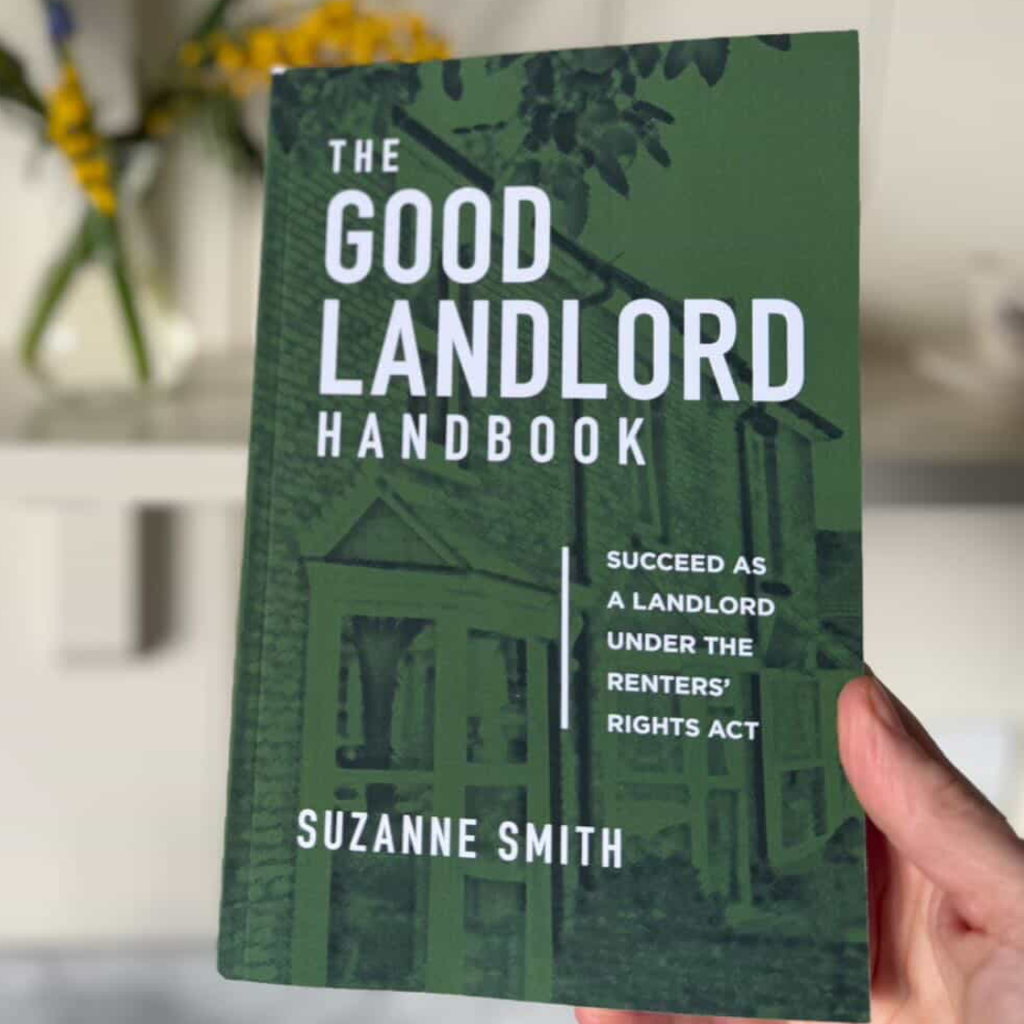 Reader holding The Good Landlord Handbook in their home